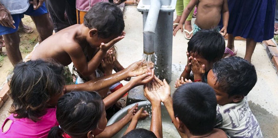 children get water from a well dug by a Christian ministry in cambodia